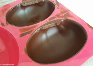 On râcle la surface du moule avant que le chocolat soit cristallisé pour des bords réguliers