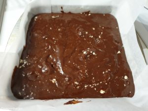versement de la pâte à brownie avec halva en morceaux